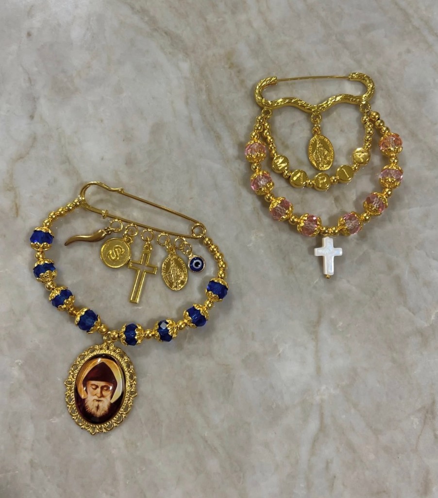 Beaded hanging pins with saint medals, letter beads, and extra charms.